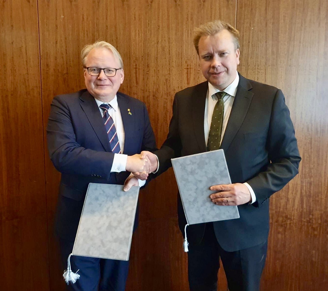 Finlands försvarsminister Antti Kaikkonen och Sveriges försvarsminister Peter Hultqvist skakar hand. De håller samförståndsavtal om värdlandsstöd mellan Finland och Sverige.